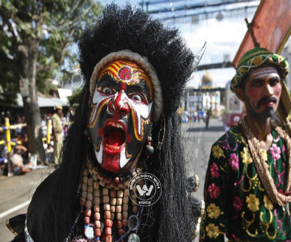 An artist dressed as a devil gestures